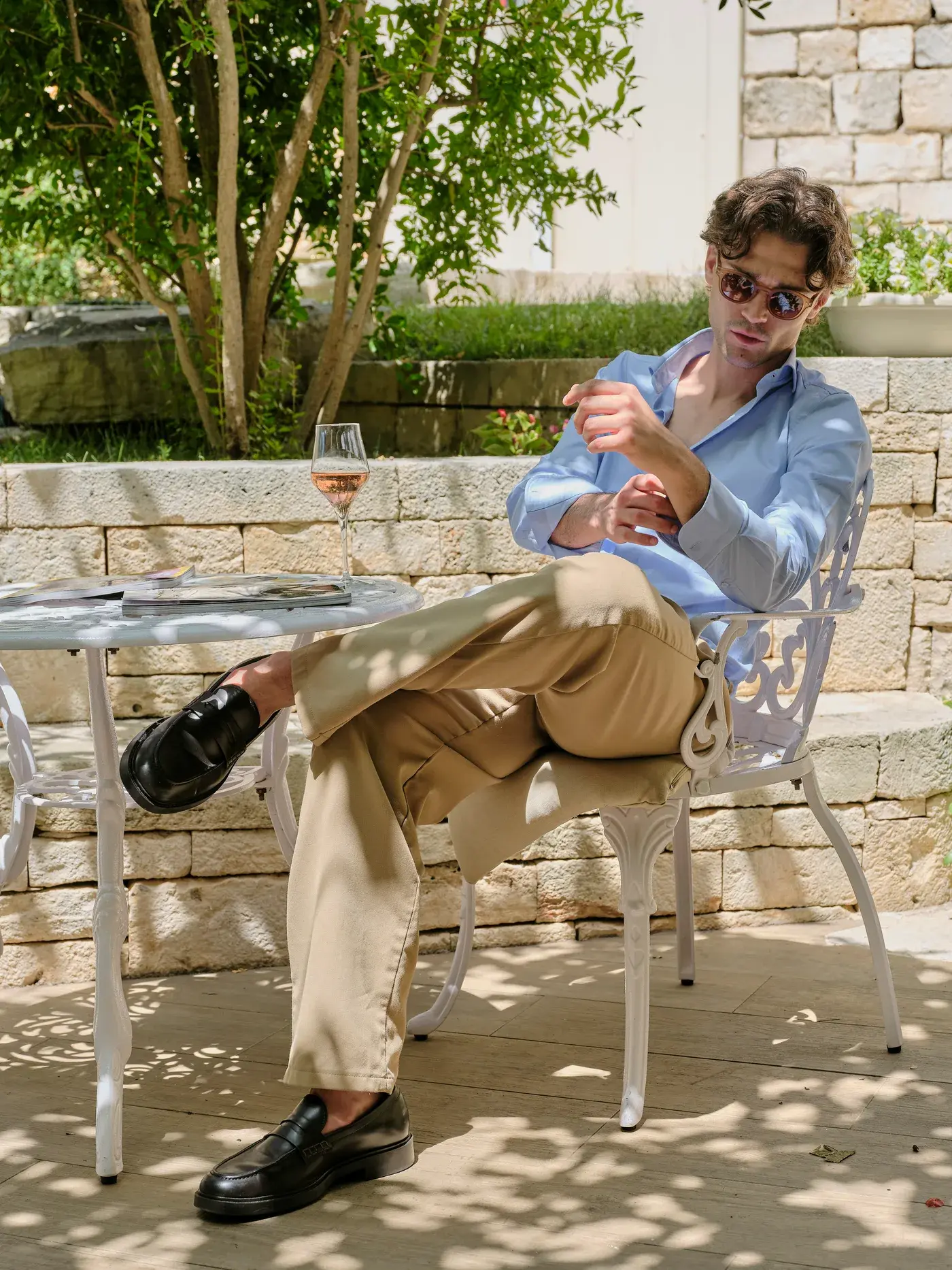 L'aperitivo da NOS — un calice di vino bianco nel verde del giardino