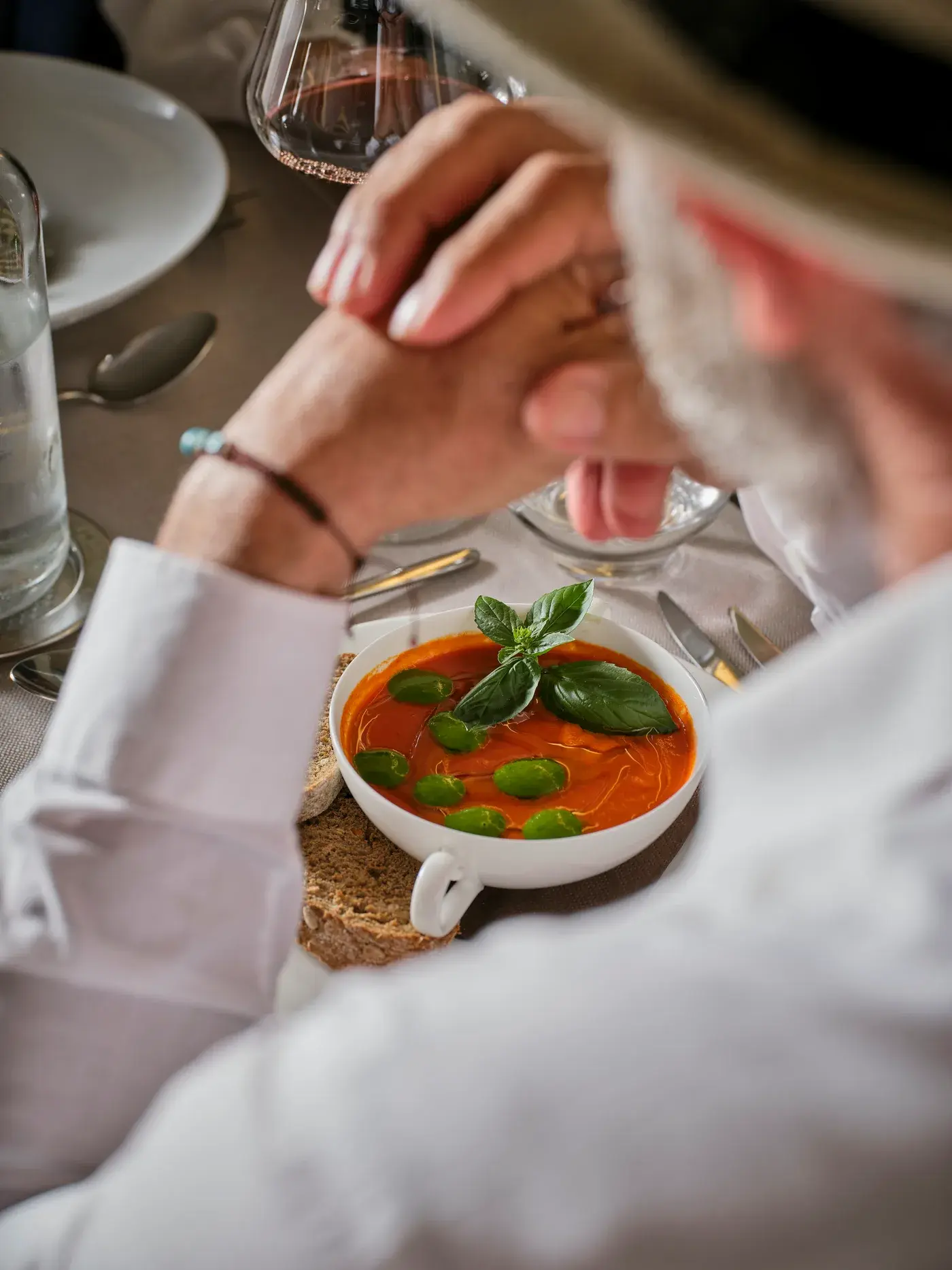 Il pranzo all'aperto da NOS — amici a tavola sotto il pergolato di vite, tra luce e verde